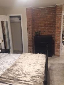 a bedroom with a bed and a brick wall at Bauer Terrace - Cozy 1 bedroom beside The Citadel in Halifax