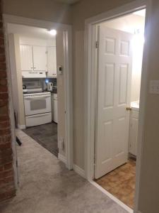 a kitchen with a white door and an open doorway at Bauer Terrace - Cozy 1 bedroom beside The Citadel in Halifax