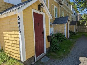 a yellow house with a red door on it at Bauer Terrace - Cozy 1 bedroom beside The Citadel in Halifax