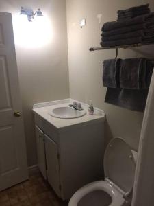 a bathroom with a white toilet and a sink at Bauer Terrace - Cozy 1 bedroom beside The Citadel in Halifax