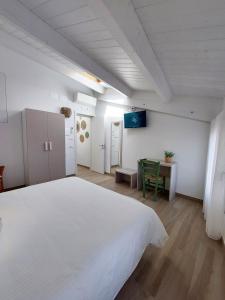 um quarto com uma grande cama branca e uma mesa em Affittacamere Casa Lilibet em San Benedetto del Tronto