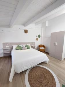 a white bedroom with a large bed and a rug at Affittacamere Casa Lilibet in San Benedetto del Tronto
