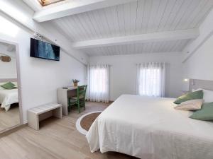 Habitación blanca con cama y escritorio en Affittacamere Casa Lilibet, en San Benedetto del Tronto