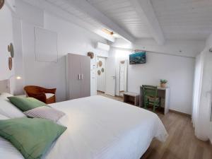 a white bedroom with a large bed and a table at Affittacamere Casa Lilibet in San Benedetto del Tronto