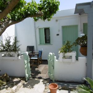 Skyros Panorama Studios في سكيروس: منزل بجدران بيضاء وطاولة مع نباتات الفخار