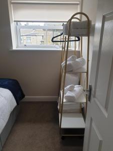 Freedom Hall Apartment في Queensbury: غرفة مع سرير بطابقين ورف مع المناشف