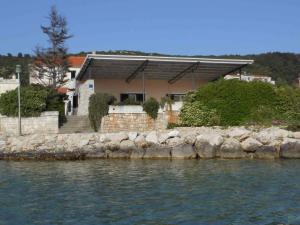 a house on the shore of a body of water at Apartments Eugenio Turizam in Soline