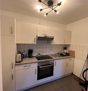 a kitchen with white cabinets and a stove top oven at Apartment mit guten Anbindungen in Magdeburg