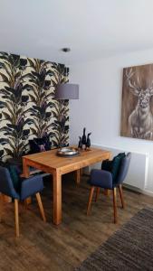 a dining room with a wooden table and two chairs at Maurers Schlierseetraum 6, Studio 455 mit 42 qm neu renoviert, Erdgeschoss mit eingezäunter Terrasse in ruhiger Lage am Kirchbichlweg 8 in Schliersee