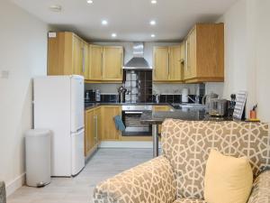 uma cozinha com armários de madeira e um frigorífico branco em Moat View em Brampton