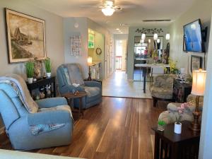 sala de estar con 2 sillas azules y mesa en Romantic Island condo for 2 - Sunset Harbor 1-205 - Navarre Beach, en Navarre