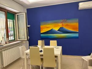 una sala da pranzo con tavolo e parete blu di Dimora Anema e Core a Napoli