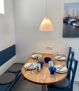 einen Holztisch mit Stühlen und viel Licht in der Unterkunft 1008 - Bungalow Ziegenbalg in Dahme