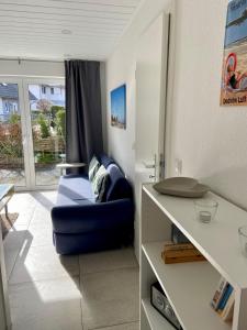 ein Wohnzimmer mit einem blauen Sofa und einem Tisch in der Unterkunft 1008 - Bungalow Ziegenbalg in Dahme