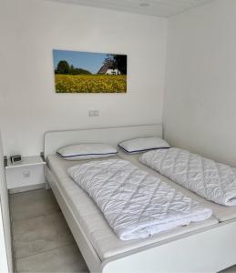 ein Schlafzimmer mit zwei Betten und einem Bild an der Wand in der Unterkunft 1008 - Bungalow Ziegenbalg in Dahme
