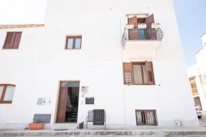 un bâtiment blanc avec deux chaises devant dans l'établissement A pochi passi dal mare, à San Vito Lo Capo