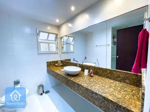 La salle de bains est pourvue d'un lavabo et d'un miroir. dans l'établissement Apartamento completo em frente ao Farol da Barra, à Salvador