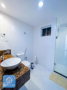 La salle de bains est pourvue d'un lavabo et de toilettes. dans l'établissement Apartamento completo em frente ao Farol da Barra, à Salvador