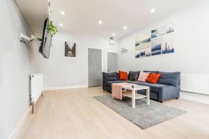 ein Wohnzimmer mit einem blauen Sofa und einem Tisch in der Unterkunft Lavish 2- bedroom Flat with Free Parking in Birmingham + 18 Fotos