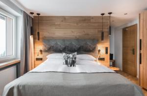 a bedroom with a large bed with wooden walls at Natur- & Genießerhotel Der Birkenhof in Oberstaufen