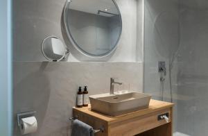 a bathroom with a sink and a mirror on the wall at Natur- & Genießerhotel Der Birkenhof in Oberstaufen