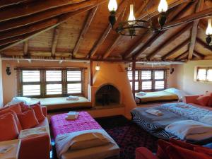 a large room with two beds and a fireplace at Large Stone Villa with garden. in Khánia