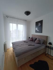 Un dormitorio con una cama grande y una ventana en Tesla Point en Osijek