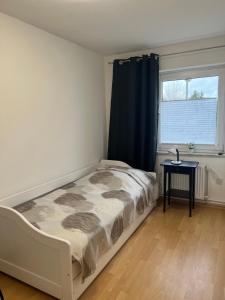 ein kleines Schlafzimmer mit einem Bett und einem Fenster in der Unterkunft Messe Zimmer/Ferienwohnung Hannover in Hannover