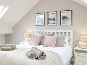 a bedroom with a white bed with four pictures on the wall at Moat View in Brampton