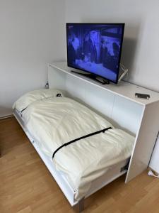 - une étagère blanche avec une télévision au-dessus dans l'établissement Messe Zimmer/Ferienwohnung Hannover, à Hanovre