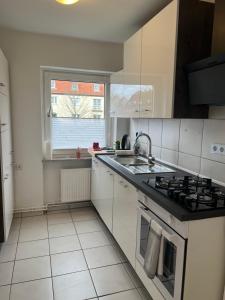 uma cozinha com um lavatório e um fogão forno superior em Messe Zimmer/Ferienwohnung Hannover em Hanôver