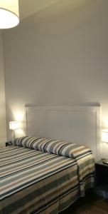 uma cama num quarto com duas lâmpadas em Vada al Mare Apartments em Vada