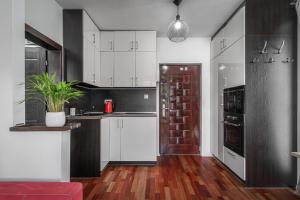 Vysoke Tatry - Horny Smokovec的住宿－Apartman pod Gerlachom s wellness，厨房配有白色橱柜和红色沙发