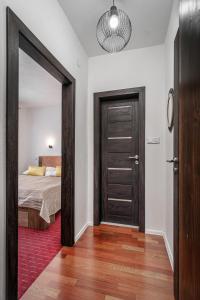 sypialnia z łóżkiem i drzwiami z lustrem w obiekcie Apartman pod Gerlachom s wellness w mieście Vysoke Tatry - Horny Smokovec