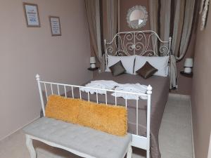 a white bed with a bench in a bedroom at Nikos Studio in Kalyves