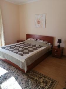 1 dormitorio con 1 cama grande y 1 alfombra en Raduga West Pineforest - коттедж в аренду на Иссык-Куле en Koshkolʼ