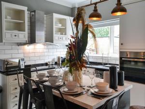 a kitchen with a wooden table with chairs and a counter top at Loyal Cerise Bondgate in Selby