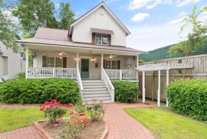a white house with a porch and a fence at Village Walk - 104 Mews Circle in King City