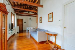 ein Wohnzimmer mit einem blauen Sofa und einem Tisch in der Unterkunft Yourbanflat Dante in Padua