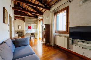 ein Wohnzimmer mit einem blauen Sofa und einem TV in der Unterkunft Yourbanflat Dante in Padua