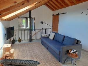 a living room with a blue couch and a table at Casa de Santo Amaro in Santo Amaro