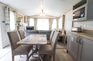 a dining room and kitchen with a table and chairs at Hayley's Holiday Haven in Weeley