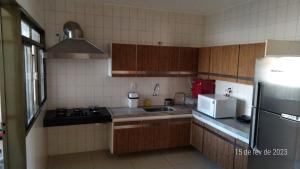 eine Küche mit einer Spüle und einem Kühlschrank in der Unterkunft Apartamento Uberlândia - Centro com garagem in Uberlândia
