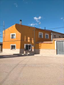 un gran edificio naranja con 2 ventanas en una calle en Casa joselito, en Casas del Cerro