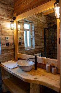 a bathroom with a stone sink and a mirror at Osada Strusie Jajo w Bieszczadach in Ustrzyki Dolne