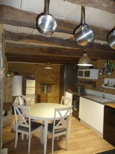 eine Küche mit einem Tisch und Stühlen im Zimmer in der Unterkunft Petite maison de caractère in Le Bousquet