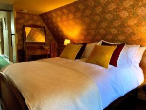 a bedroom with a large white bed with yellow pillows at The Old Wing in Alexandria