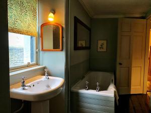 a bathroom with a sink and a bath tub at The Old Wing in Alexandria