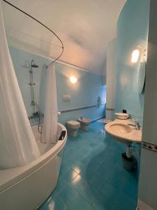 a bathroom with two toilets and a tub and a sink at Bed & Breakfast Scià Dina in Toirano