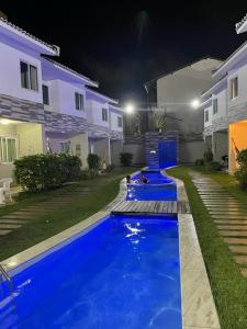 a swimming pool in front of a house at night at Casa de Luxo, 1 quadra do Mar em Porto de Galinhas in Porto De Galinhas